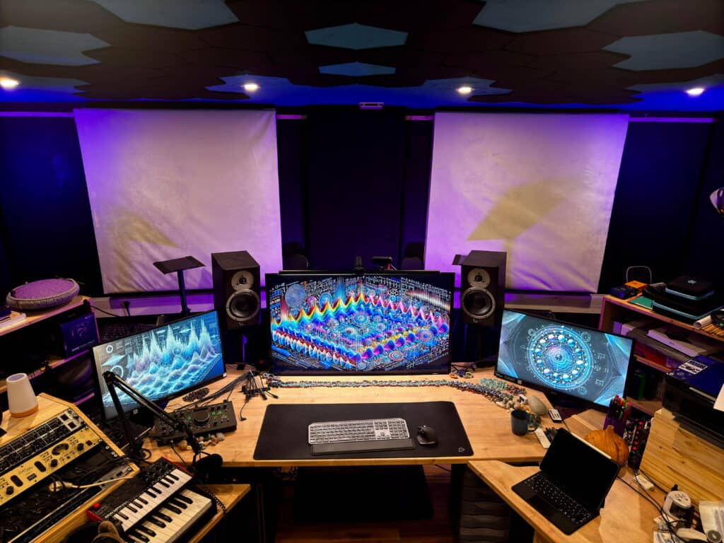 Poste de travail du Sound Up Studio avec plusieurs écrans affichant des visualisations audio, un clavier MIDI et du matériel de production.