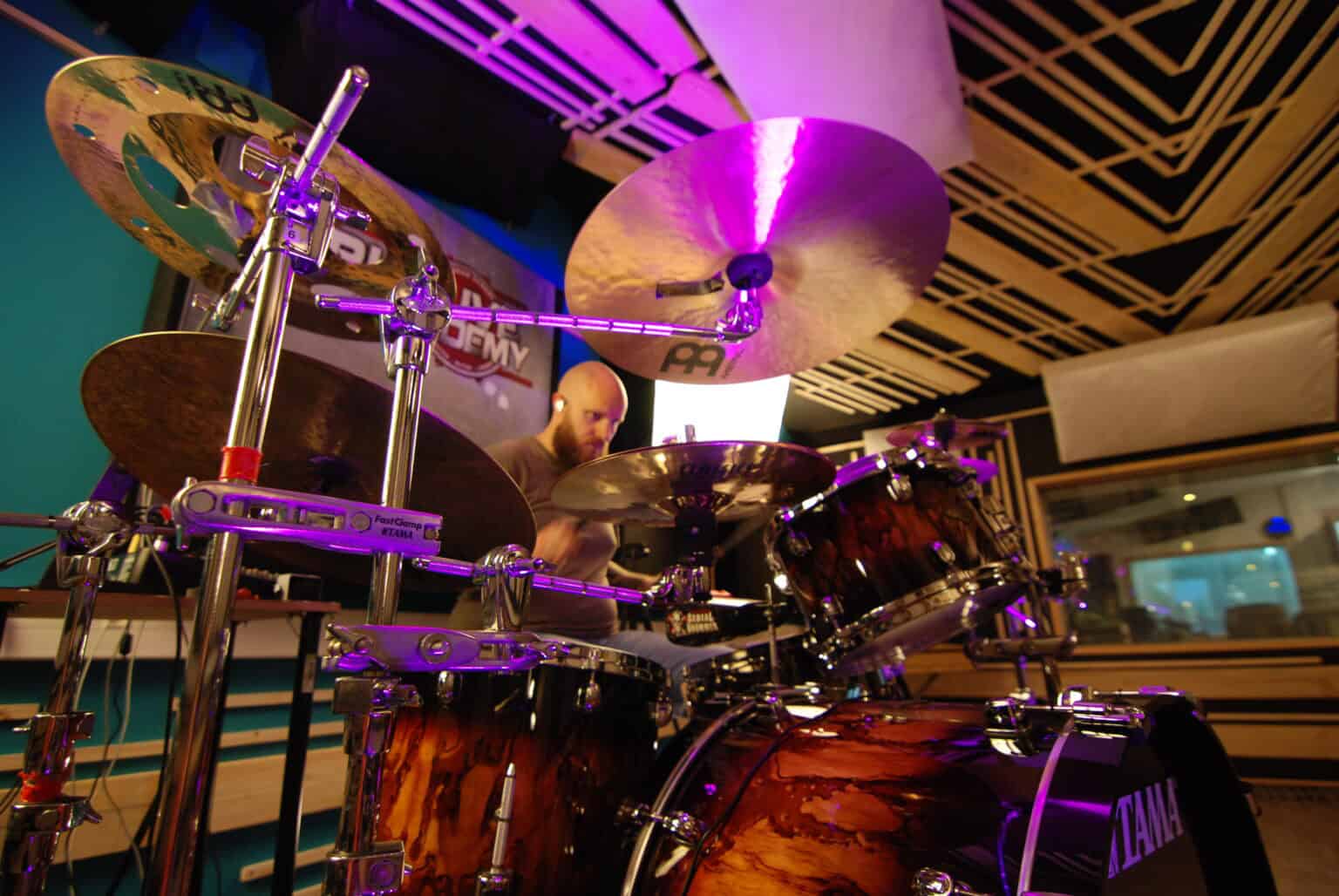 Batteur en pleine session d’enregistrement au Sound Up Studio, capturé sous un éclairage d’ambiance immersive.