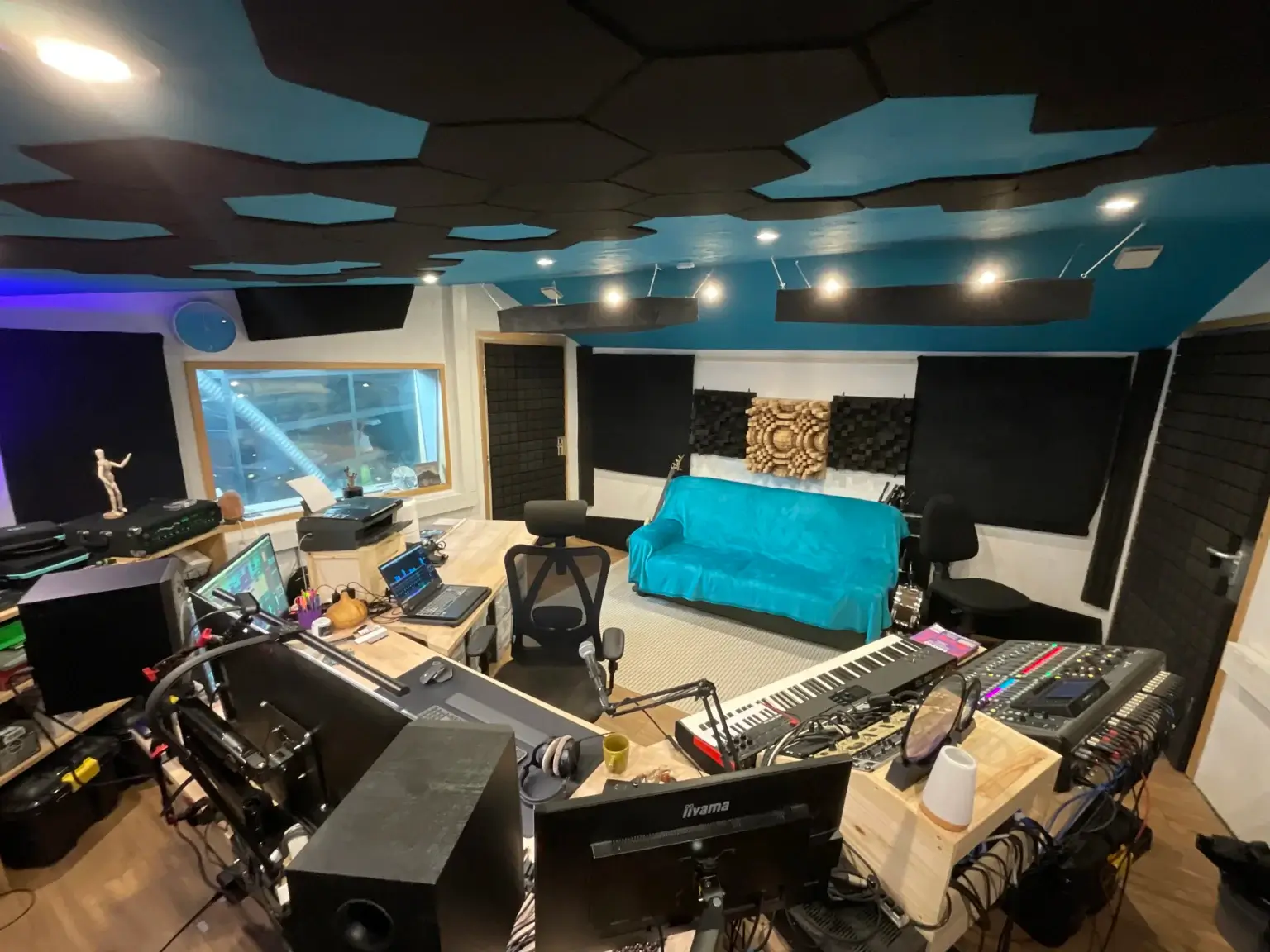 Salle de monitoring du Sound Up Studio avec un traitement acoustique avancé et un espace de travail ergonomique.