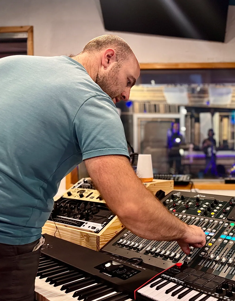 Thomas, ingénieur du son, règle la console numérique pendant une séance au Sound Up Studio.
