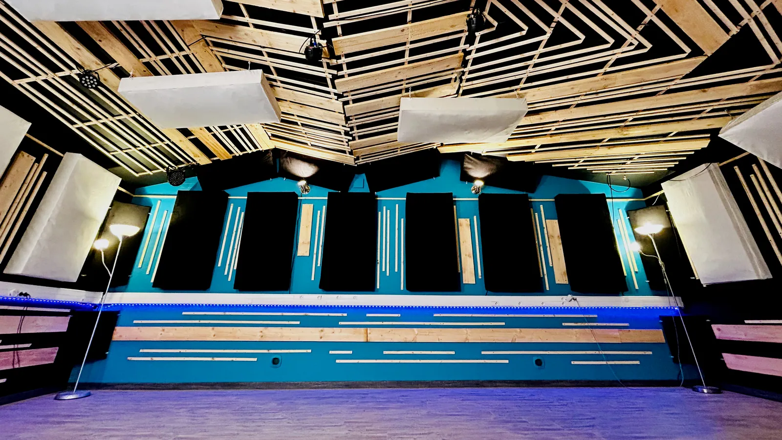La salle de prise du Sound Up Studio : plafond en lattes de bois, murs turquoise et panneaux acoustiques.